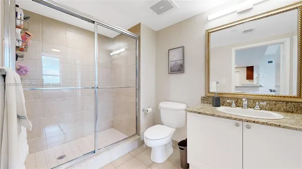a bathroom with a granite countertop sink toilet and shower