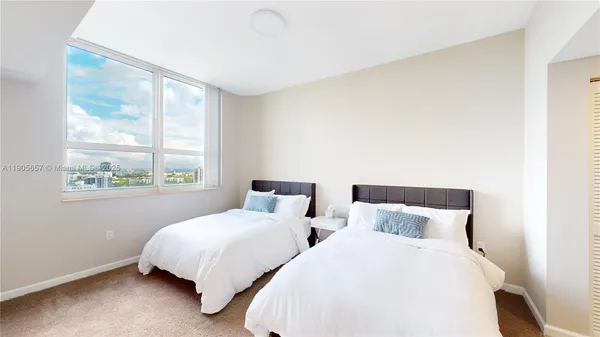 a bedroom with two beds and a large window