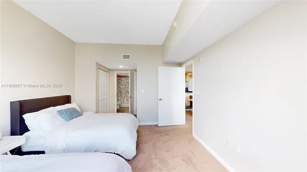 a bedroom with a large bed and a chandelier