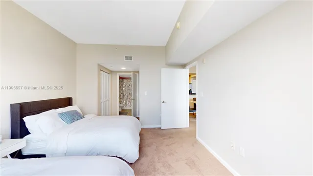 a bedroom with a large bed and a chandelier