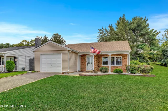 a front view of a house with a garden and yard