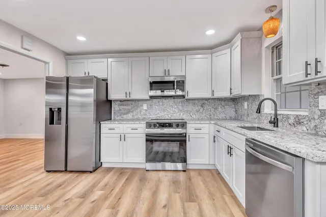 a kitchen with stainless steel appliances granite countertop a stove a sink and a refrigerator
