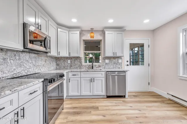 a kitchen with stainless steel appliances granite countertop a stove a sink and a microwave