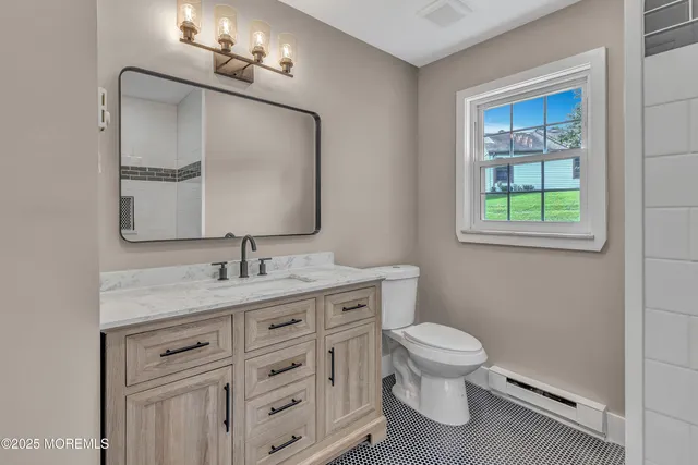 a bathroom with a granite countertop toilet sink and mirror