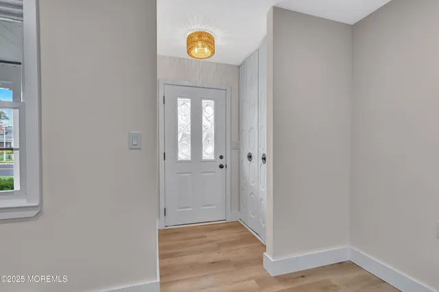 a view of a hallway with wooden floor and a window