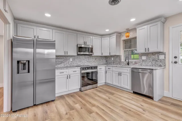 a kitchen with stainless steel appliances granite countertop a refrigerator sink and cabinets