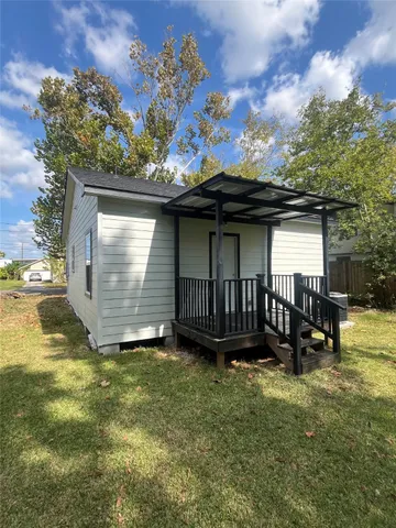 a view of a small house with a yard