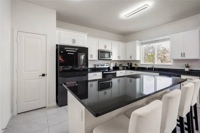 a kitchen with granite countertop white cabinets and stainless steel appliances