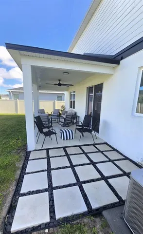 a view of a patio with table and chairs and potted plants