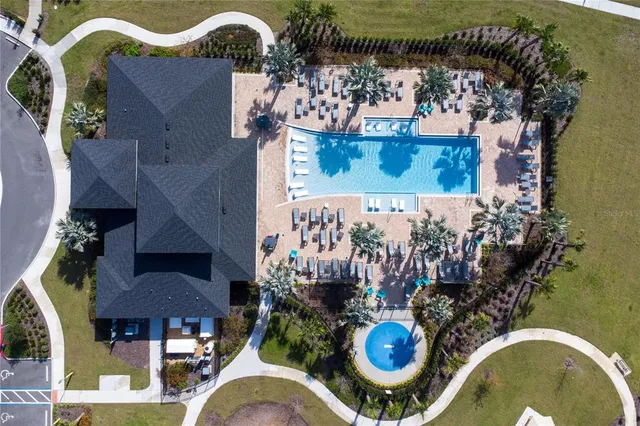 a view of a white house next to a yard with big trees