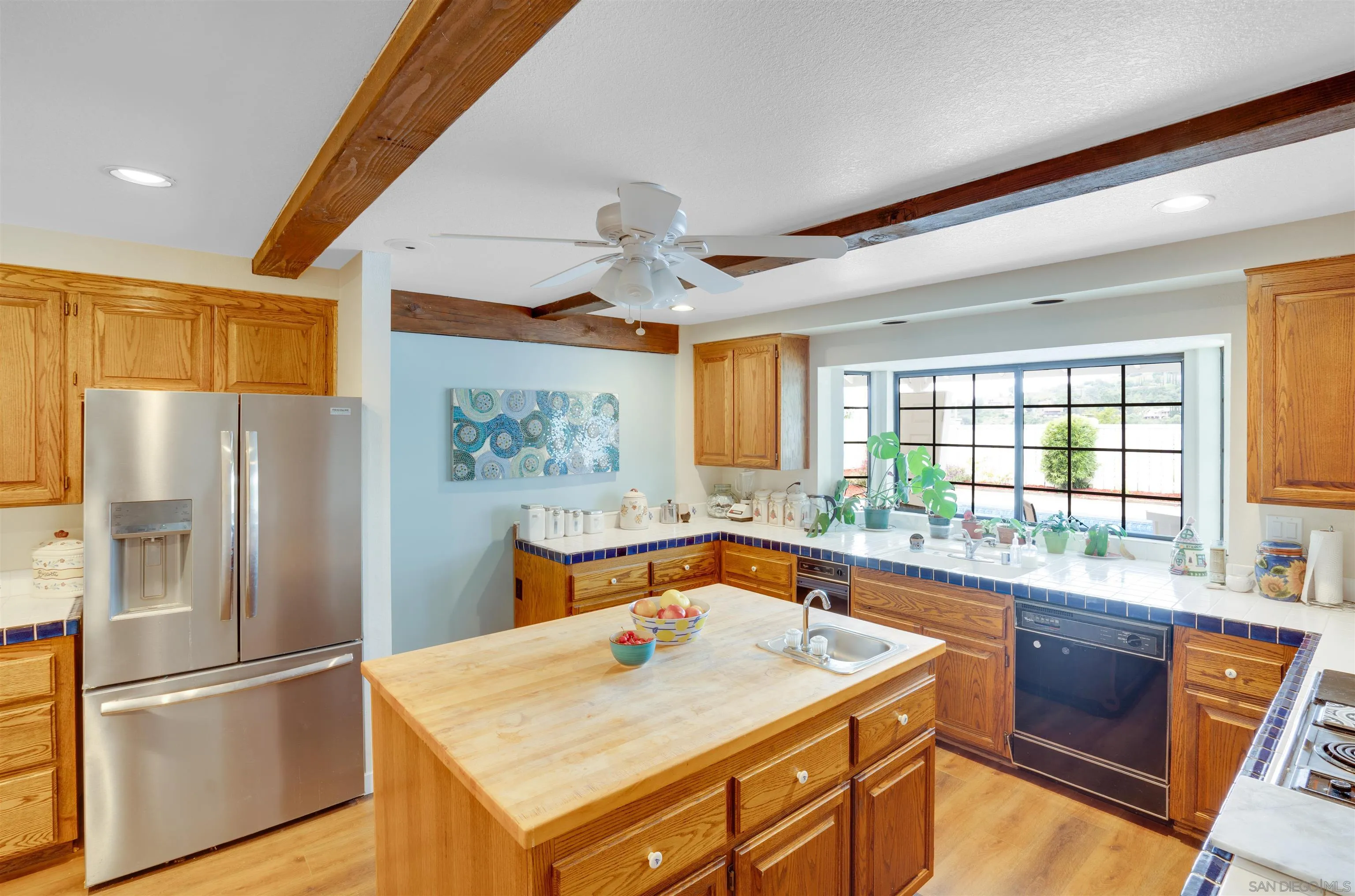 3675 Northcliff Drive Fallbrook, CA 92028 - Photo 14 of 37 a kitchen with stainless steel appliances granite countertop a refrigerator a sink dishwasher a stove with white cabinets and wooden floor