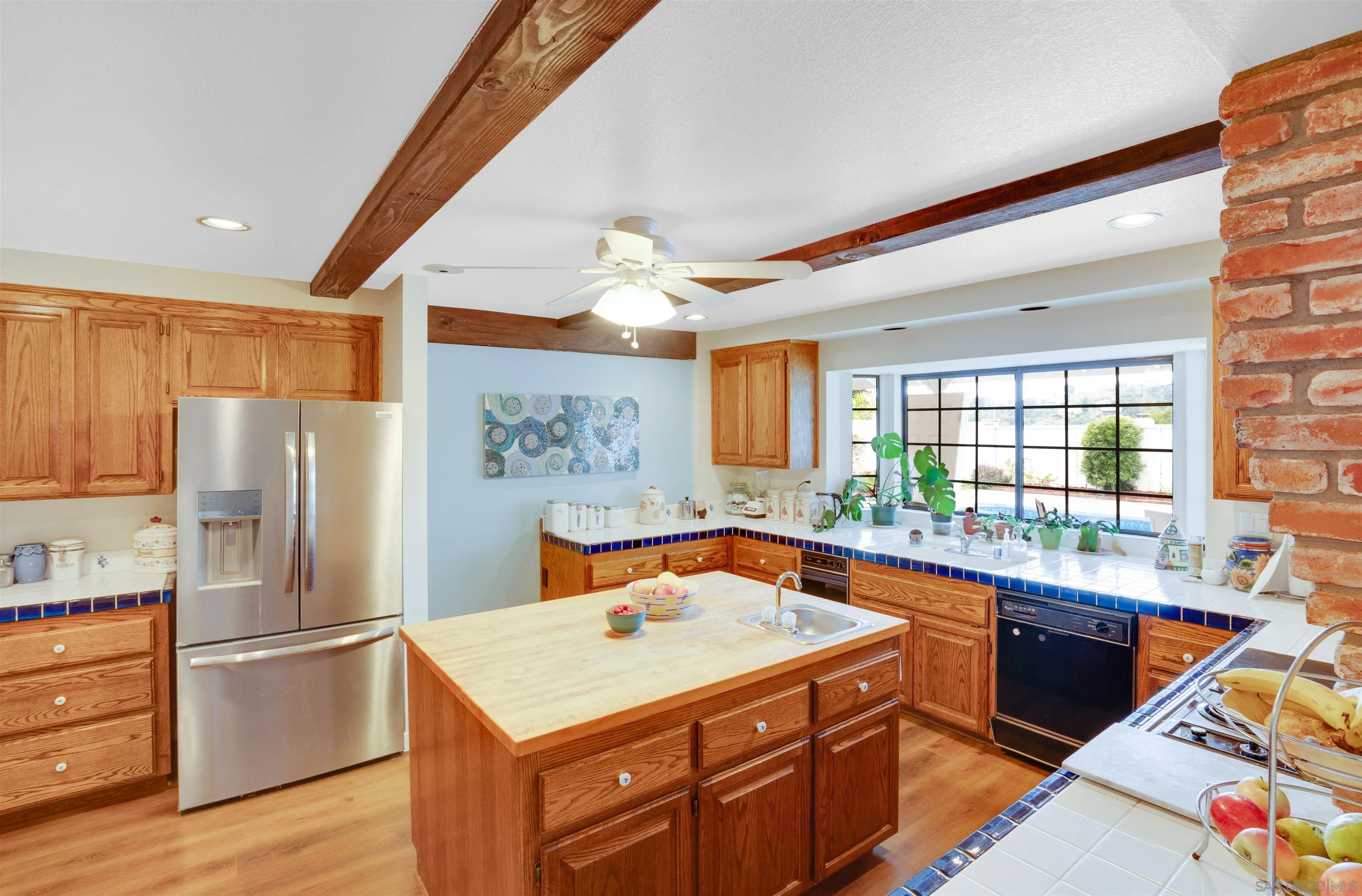 3675 Northcliff Drive Fallbrook, CA 92028 - Photo 18 of 37 a kitchen with a refrigerator a sink dishwasher and a dining table with wooden cabinet
