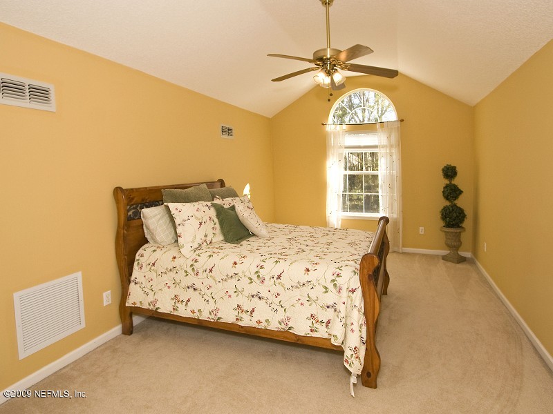 813 Mill Stream Road Ponte Vedra Beach, FL 32082 - Photo 16 of 22 a bedroom with a bed and a chandelier
