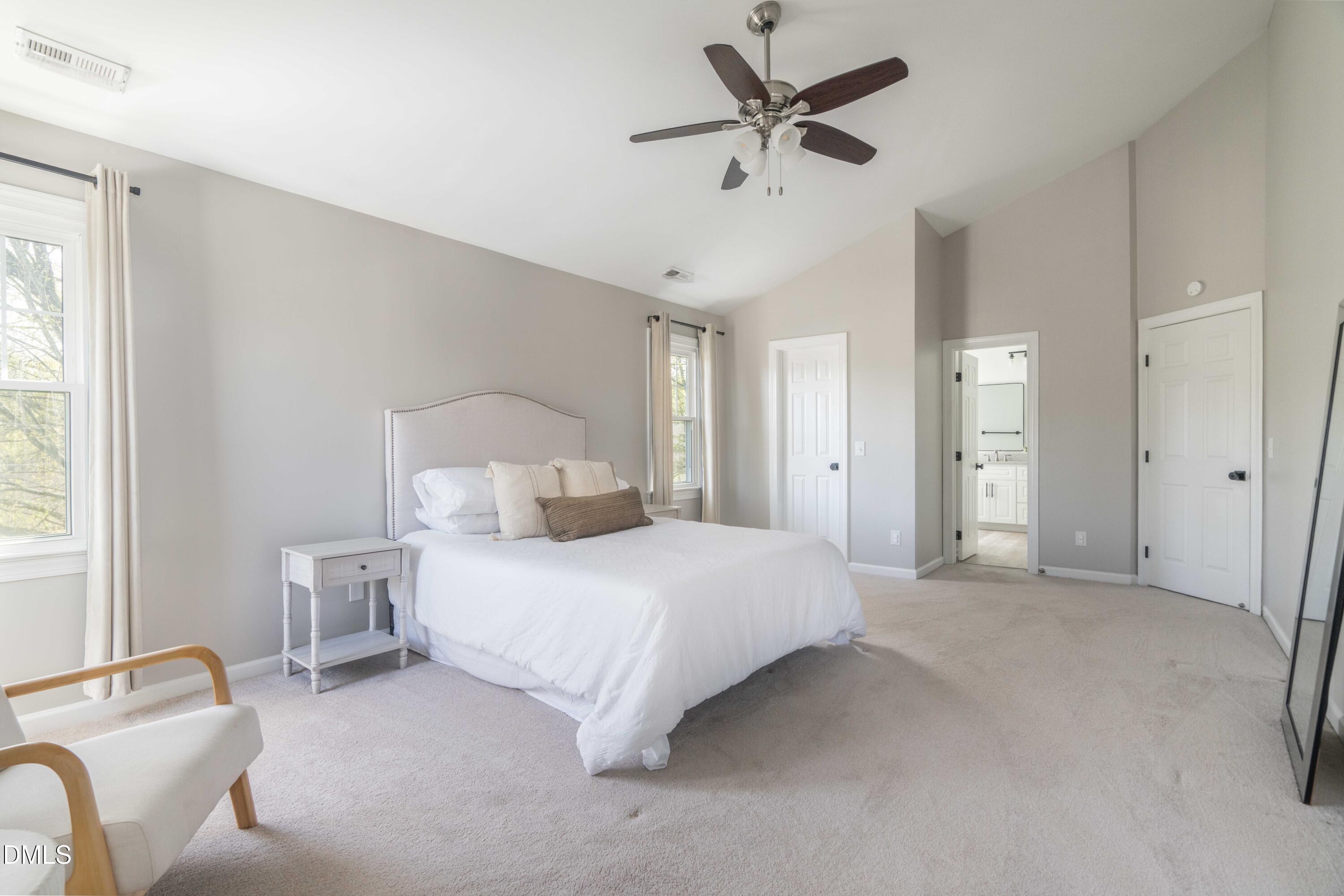 1512 Cooper Falls Lane Raleigh, NC 27614 - Photo 30 of 64 a spacious bedroom with a bed and a chandelier