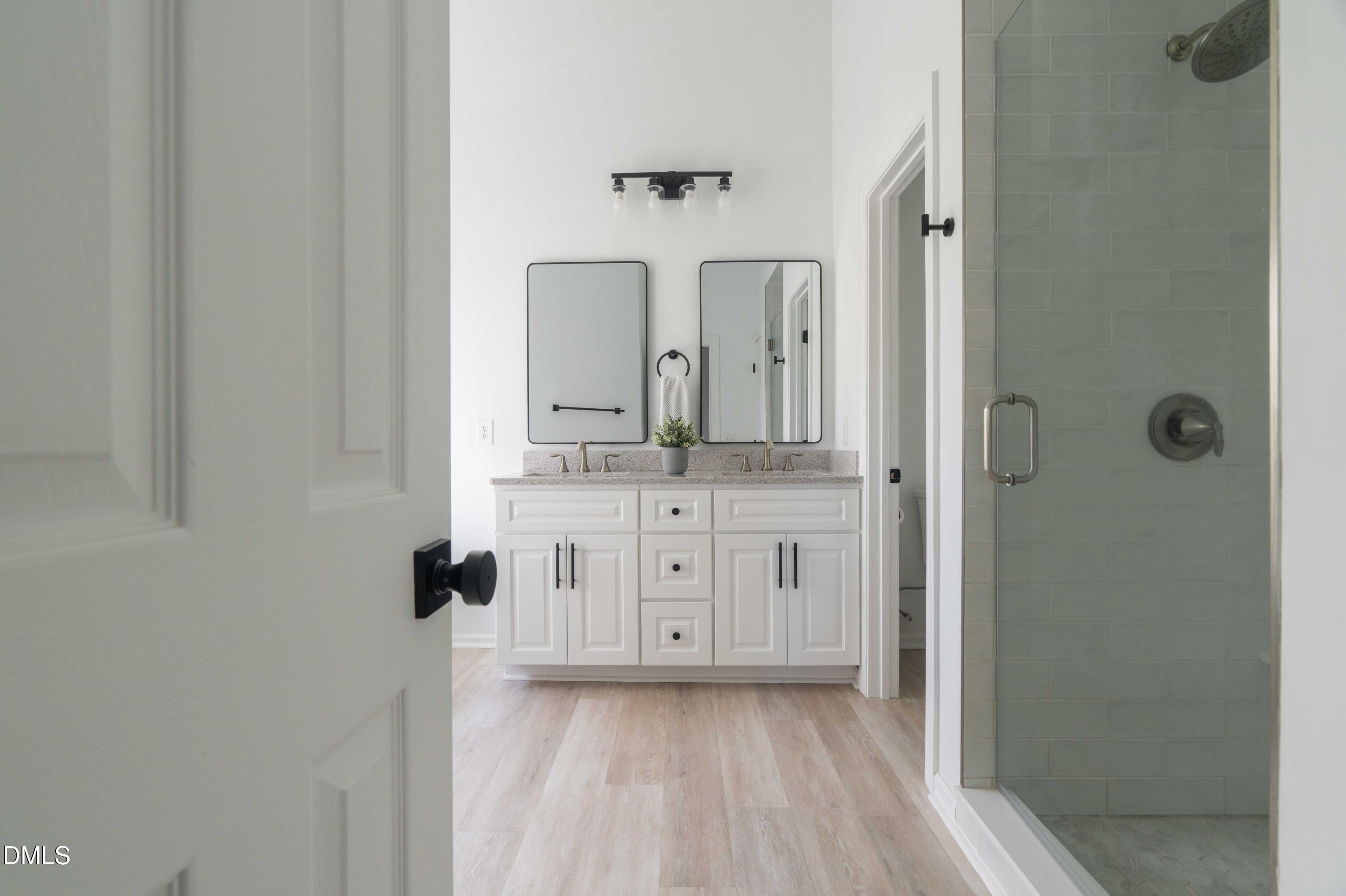 1512 Cooper Falls Lane Raleigh, NC 27614 - Photo 34 of 64 a bathroom with a double vanity sink a mirror and shower