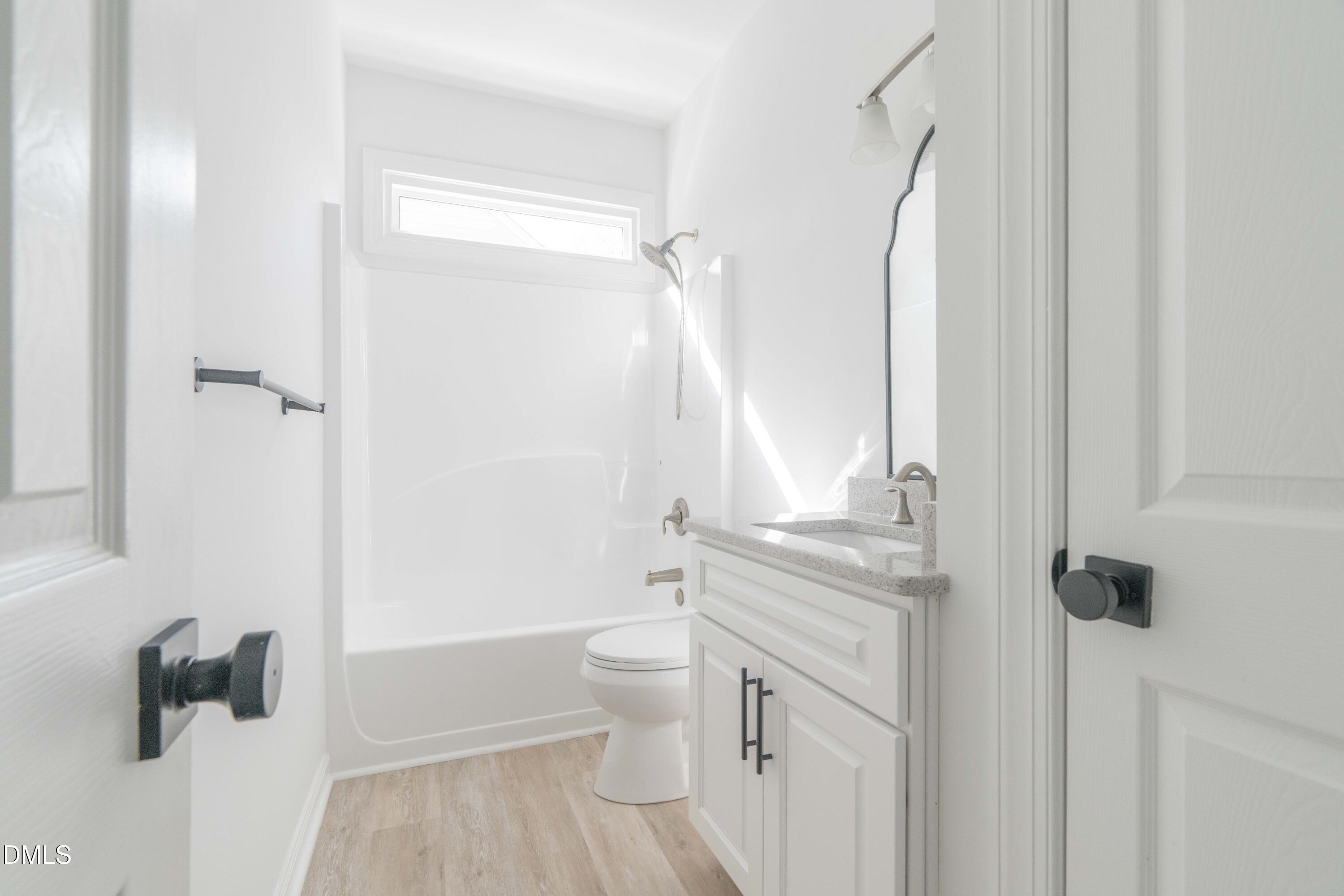1512 Cooper Falls Lane Raleigh, NC 27614 - Photo 48 of 64 a bathroom with a granite countertop sink a toilet and shower