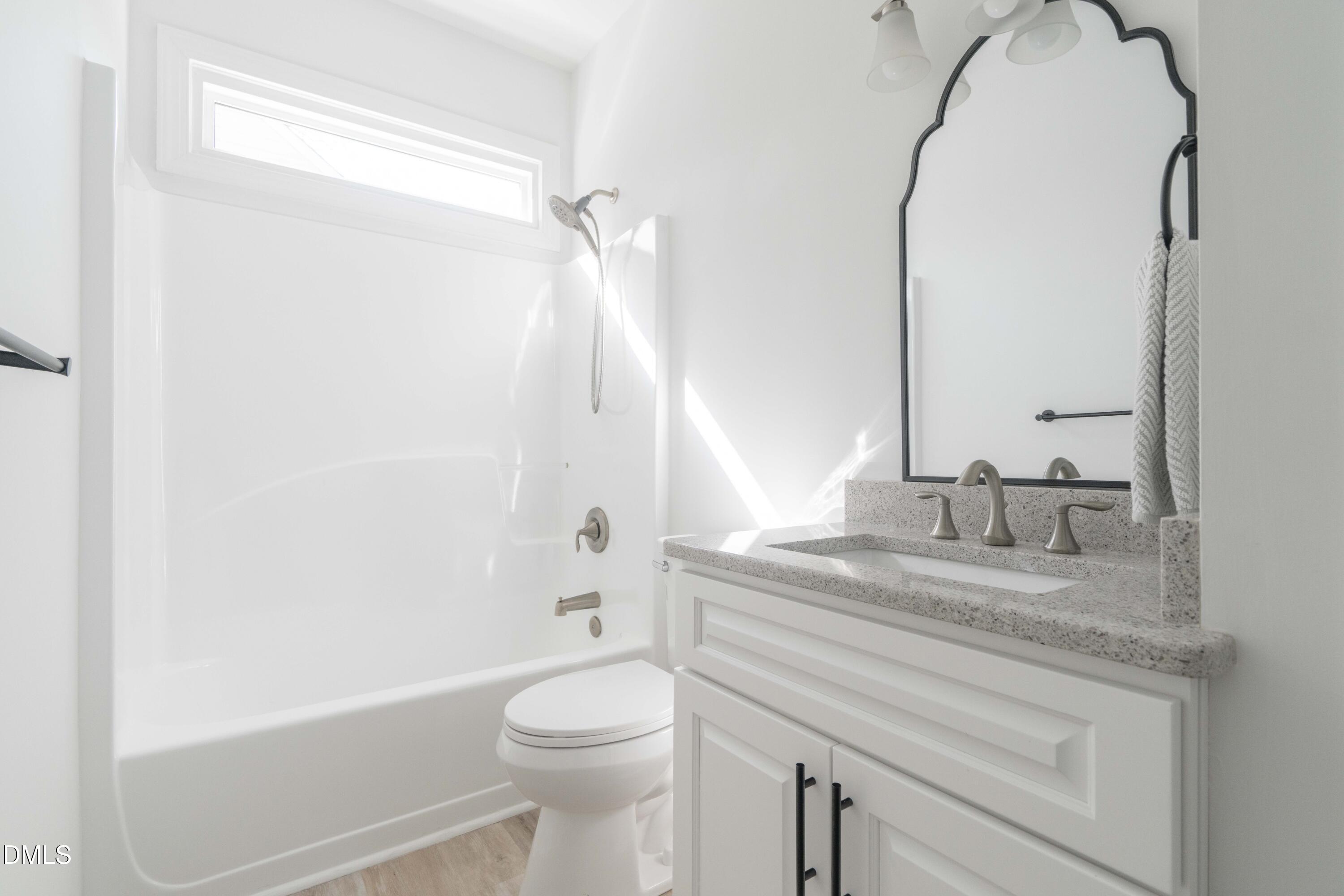 1512 Cooper Falls Lane Raleigh, NC 27614 - Photo 49 of 64 a bathroom with a granite countertop sink a toilet and shower
