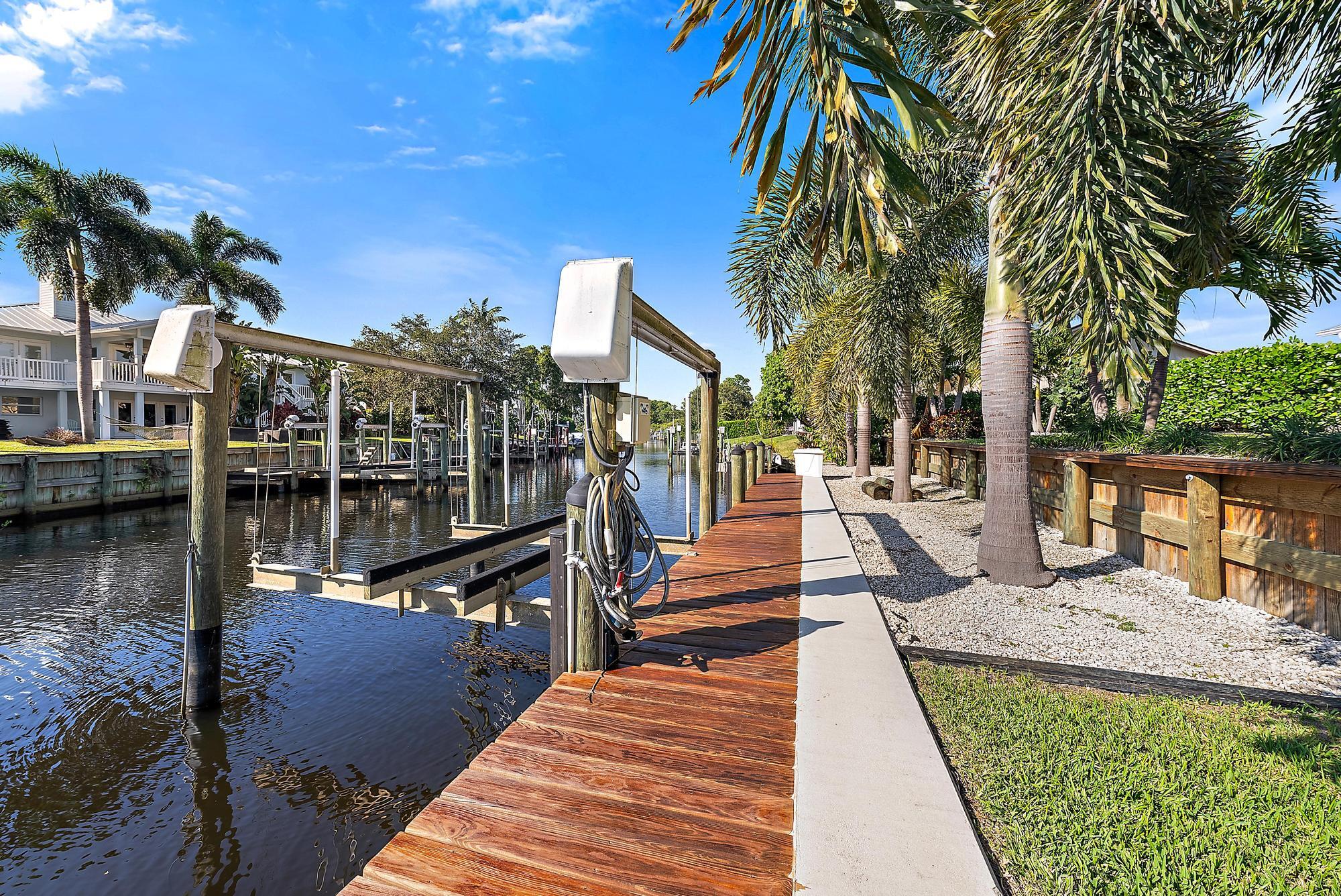 1260 Southwest 25th Lane Palm City, FL 34990 - Photo 29 of 37 a view of a swimming pool with a bench and palm trees