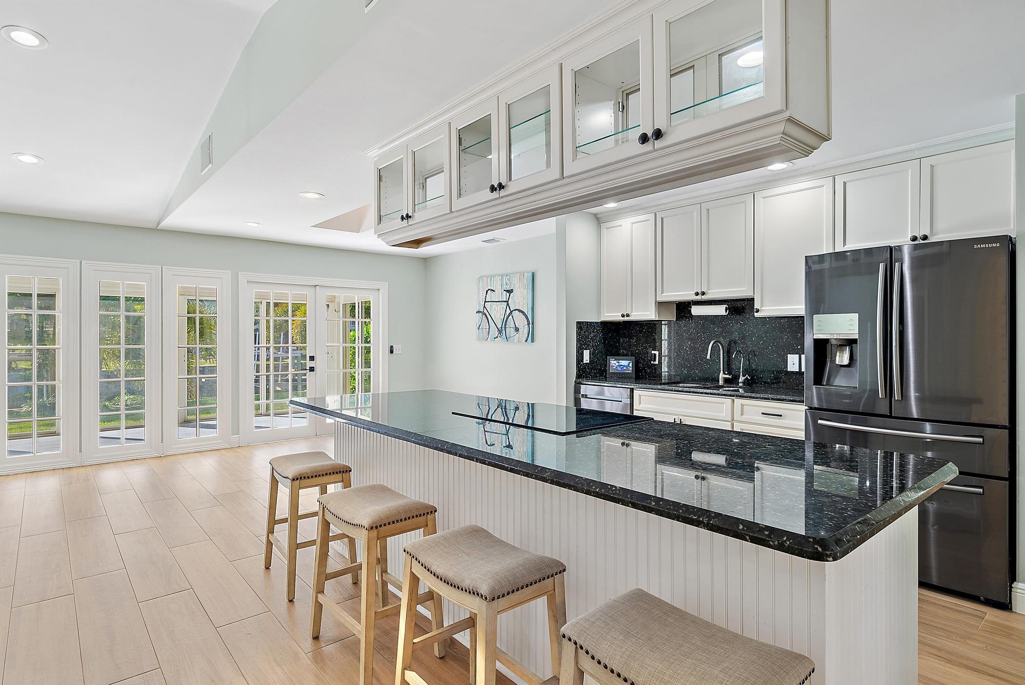 1260 Southwest 25th Lane Palm City, FL 34990 - Photo 8 of 37 a kitchen with stainless steel appliances granite countertop a sink and a refrigerator