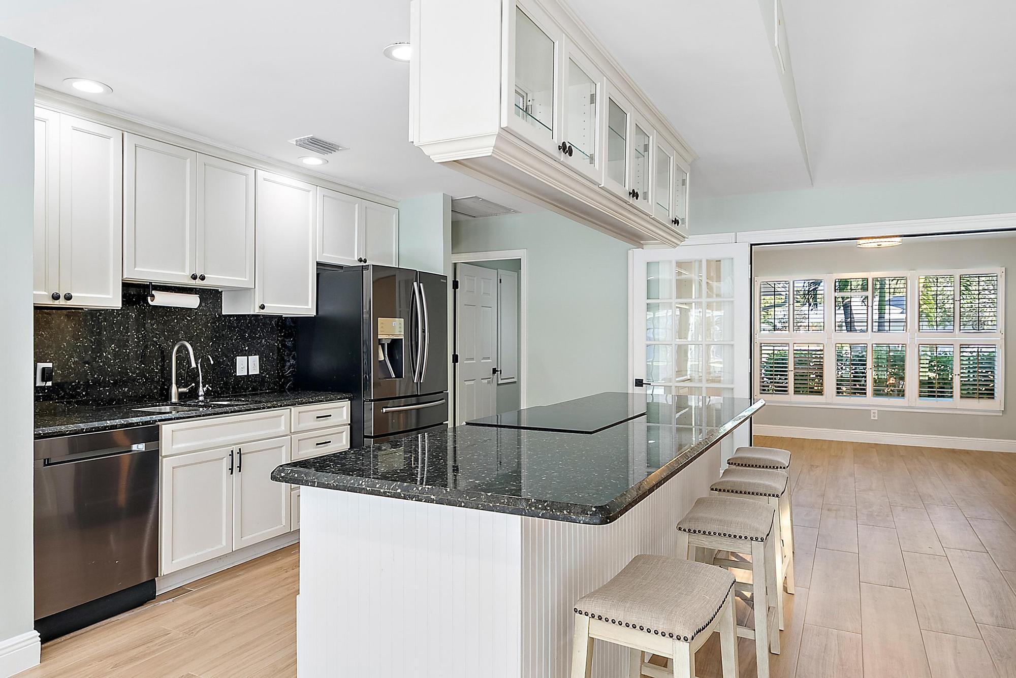1260 Southwest 25th Lane Palm City, FL 34990 - Photo 9 of 37 a kitchen with stainless steel appliances granite countertop a sink and cabinets