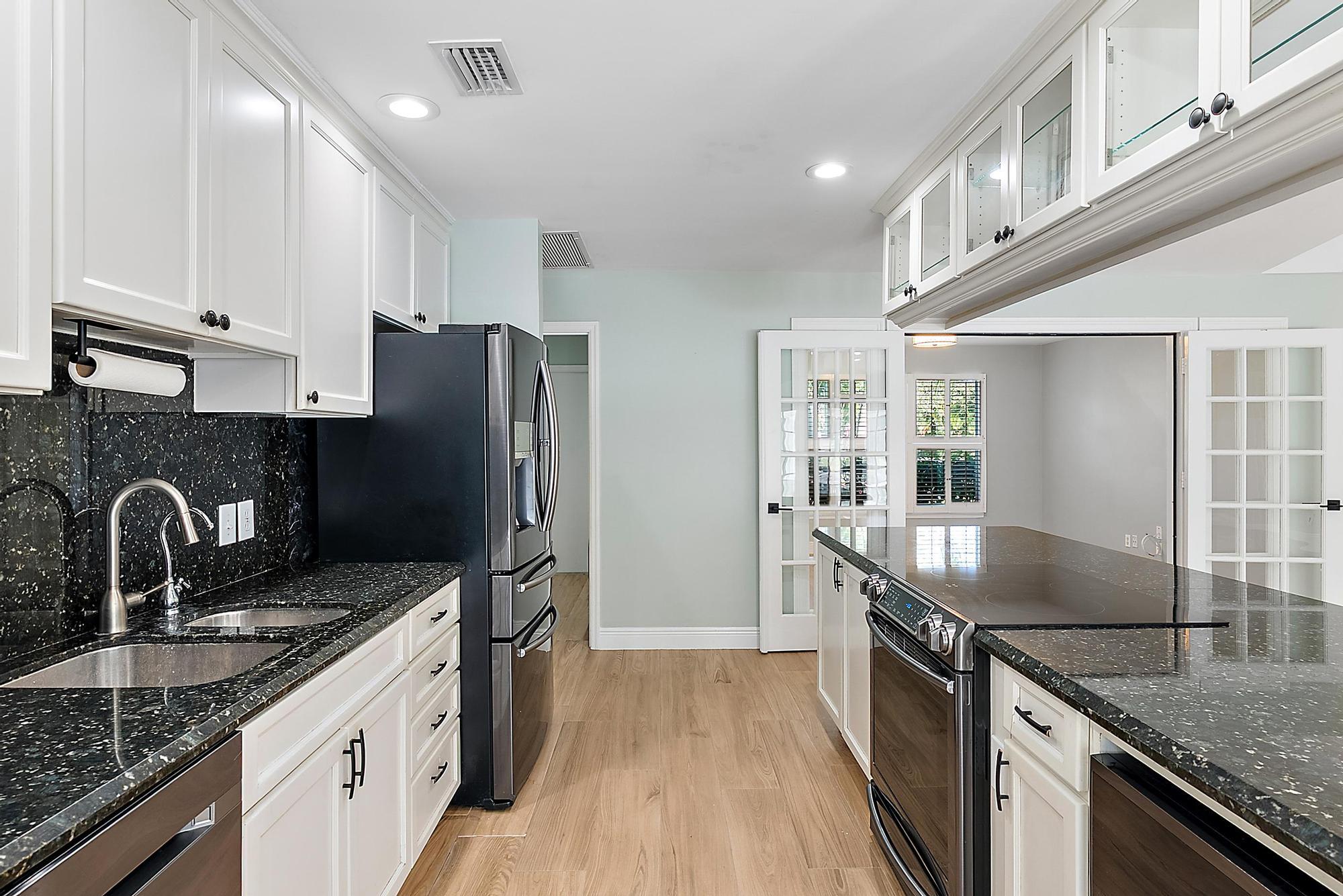 1260 Southwest 25th Lane Palm City, FL 34990 - Photo 10 of 37 a kitchen with granite countertop a sink stove and refrigerator