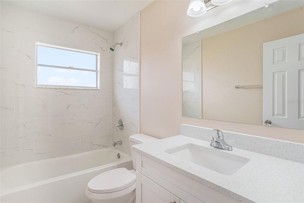 2527 Ridge Top Way Valrico, FL 33594 - Photo 18 of 29 a bathroom with a granite countertop sink toilet a mirror and bathtub