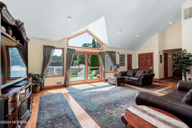 a living room with furniture a flat screen tv and a large window
