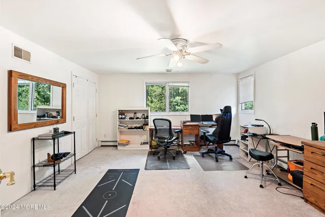 a view of a workspace with furniture and a window