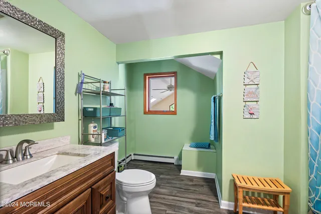 a bathroom with a granite countertop toilet sink and mirror