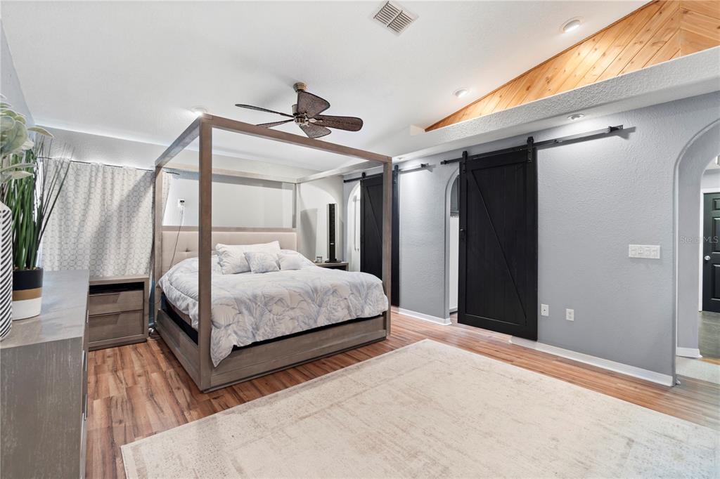 26650 Pelican Street Eustis, FL 32736 - Photo 33 of 69 a bedroom with a large bed and a chandelier