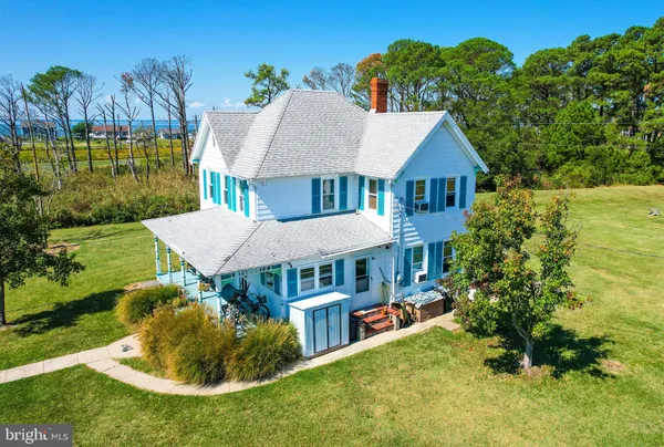 a view of a house with a big yard plants and large trees