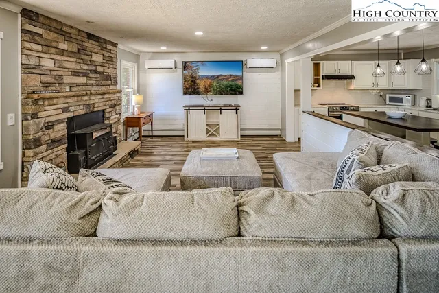 a living room with furniture a flat screen tv and a fireplace