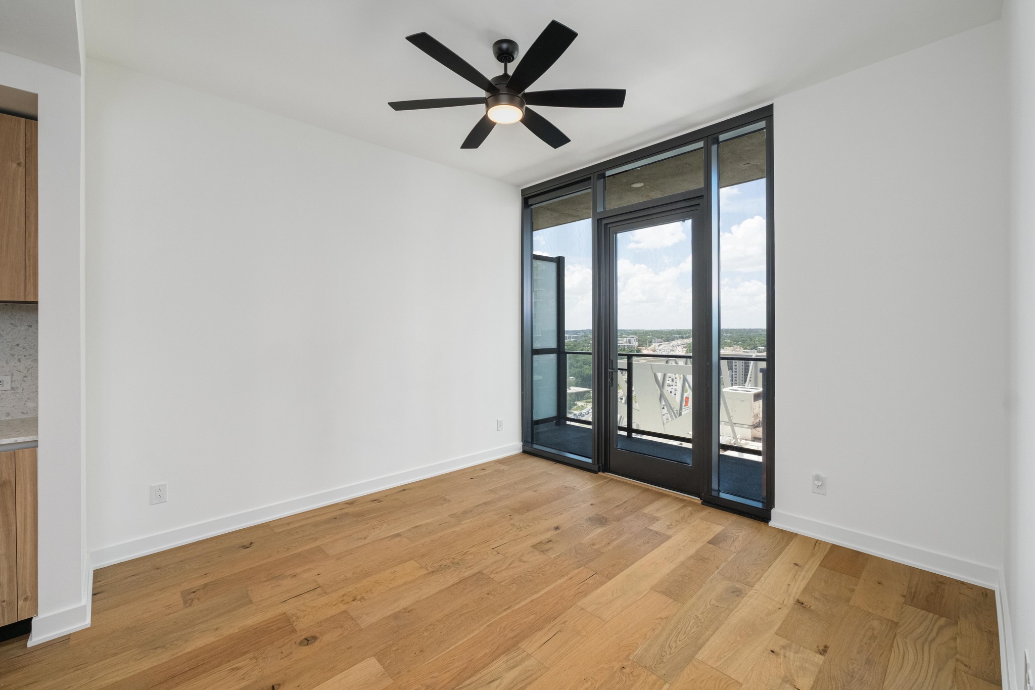 84 East Avenue, Unit 2008 Austin, TX 78701 - Photo 11 of 23 City views and a modern ceiling fan complement this room's hardwood floors and abundant natural light.