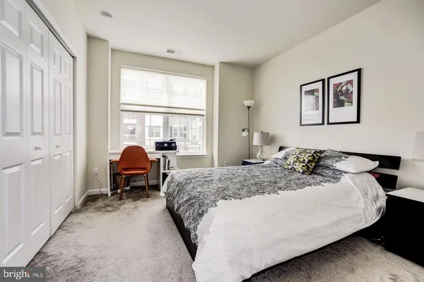 a bedroom with bed and two windows