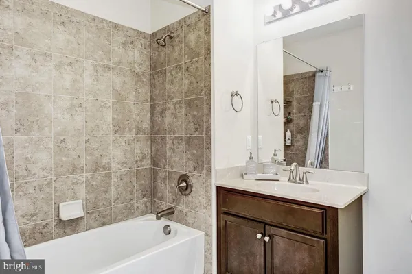 a bathroom with a sink a mirror a bathtub and shower
