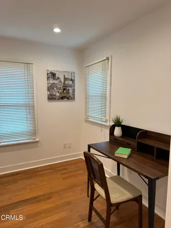 a view of a workspace with furniture and a window