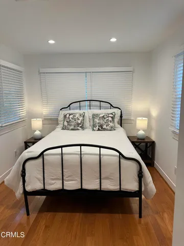 a bedroom with a bed with wooden floor