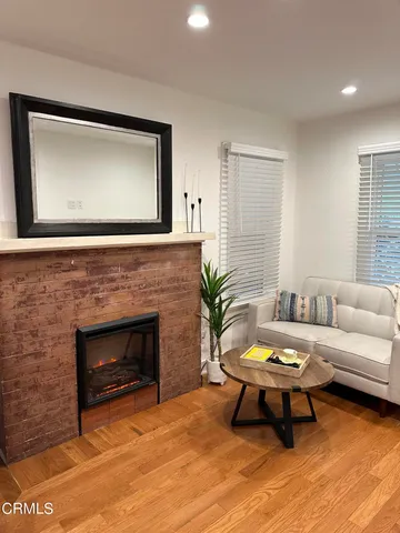 a living room with furniture a potted plant and a fireplace