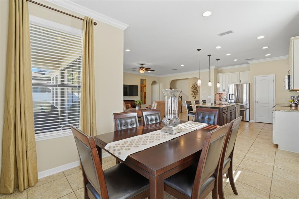 1154 Fountain Coin Loop Orlando, FL 32828 - Photo 13 of 48 a dining room with stainless steel appliances kitchen island granite countertop a dining table chairs and a refrigerator