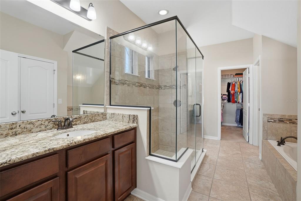 1154 Fountain Coin Loop Orlando, FL 32828 - Photo 20 of 48 a bathroom with a granite countertop sink a mirror and shower