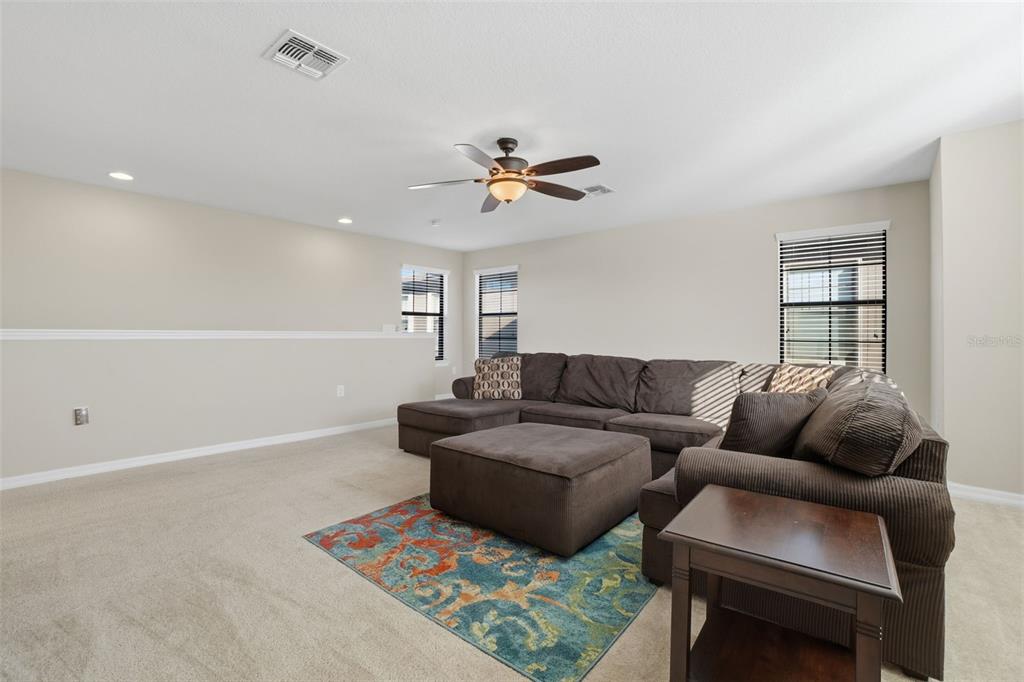 1154 Fountain Coin Loop Orlando, FL 32828 - Photo 29 of 48 a living room with furniture a ceiling fan and a rug