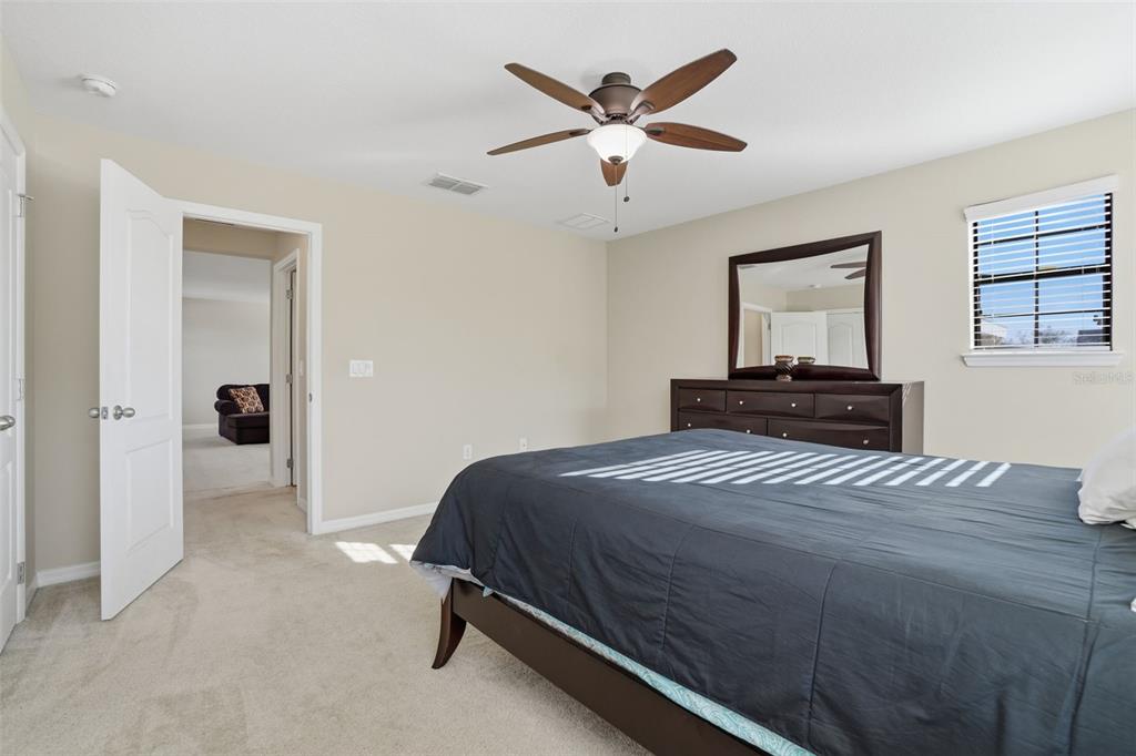 1154 Fountain Coin Loop Orlando, FL 32828 - Photo 32 of 48 a bedroom with a bed and a chandelier