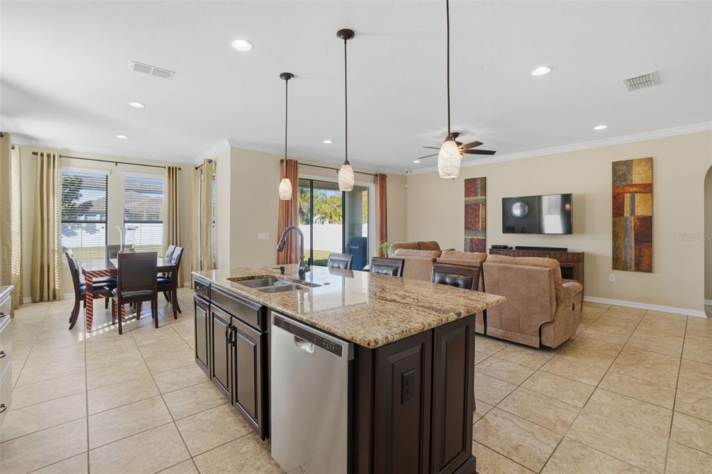 1154 Fountain Coin Loop Orlando, FL 32828 - Photo 10 of 48 a kitchen with stainless steel appliances granite countertop a sink a stove a dining table and chairs