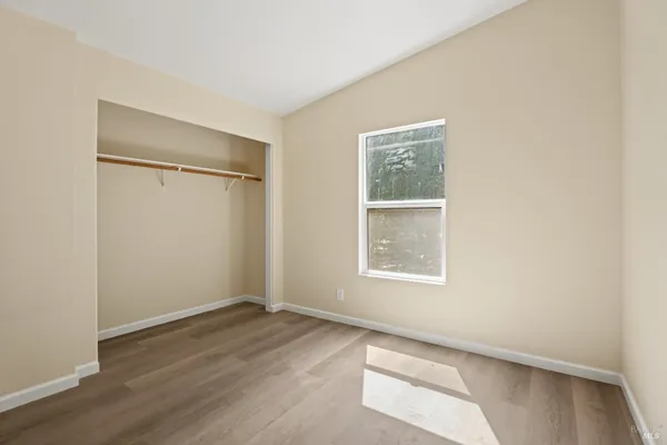 an empty room with wooden floor and a window