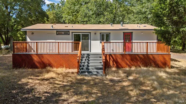 a view of a house with a yard and wooden fence