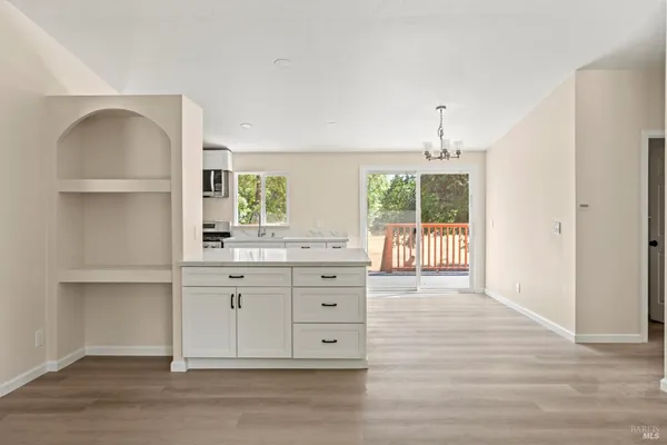 a kitchen with stainless steel appliances granite countertop a stove a sink and a refrigerator with wooden floors