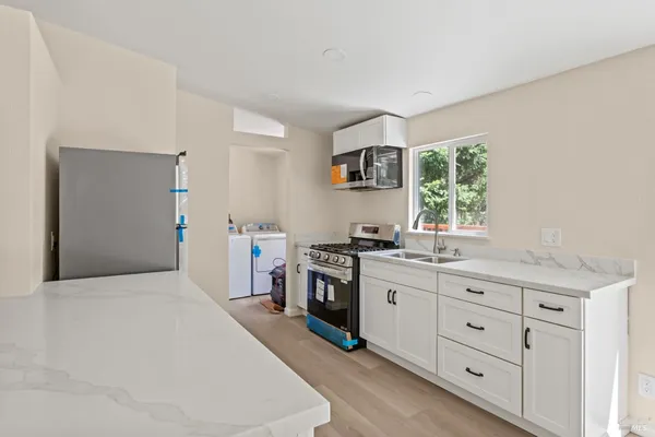 a kitchen with a stove a sink and a refrigerator