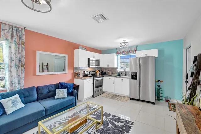 a living room with furniture and kitchen view
