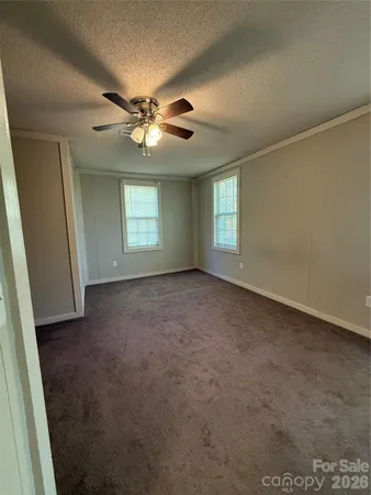 an empty room with windows and fan