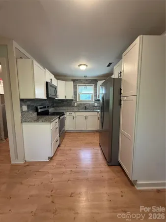 a kitchen with stainless steel appliances granite countertop a refrigerator sink and microwave